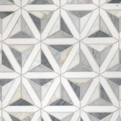 a white marble mosaic tile pattern with grey and white geometric shapes on the bottom half