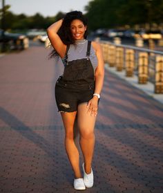 a woman in overalls posing for the camera