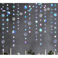 christmas decorations hanging from the side of a wall with candles and snowflakes on it