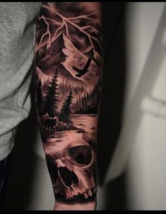 a man's arm with a skull and trees on it