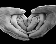 two people holding their hands in the shape of a heart with baby's feet