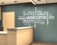 a welcome sign is displayed on the wall in an office setting with wood cabinets and blue walls