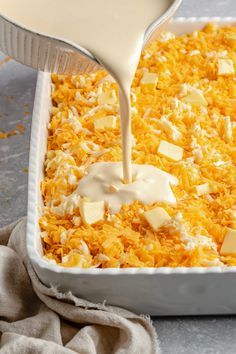 cheese being poured into a casserole dish