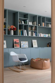 a living room filled with furniture and bookshelves next to a wooden flooring