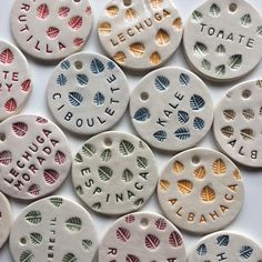 several ceramic tags with words and leaves on them