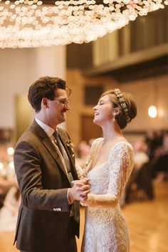 a bride and groom dance together at their wedding reception in an elegant ballroom with chandeliers overhead