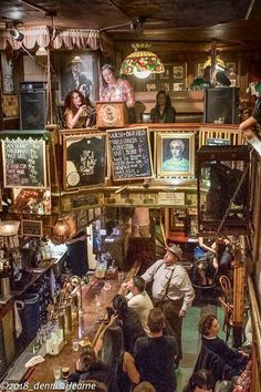 a group of people sitting at a bar with lots of chalkboards on the wall