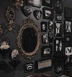 a black wall covered in pictures and mirrors