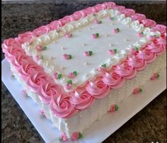 a large white and pink cake on top of a counter