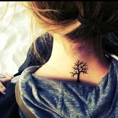 a woman with a small tree tattoo on her neck and back side ribcage