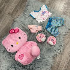 hello kitty baby clothes and accessories laid out on the floor