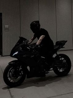 a man riding on the back of a black motorcycle