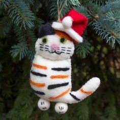 a white and orange cat ornament hanging from a tree