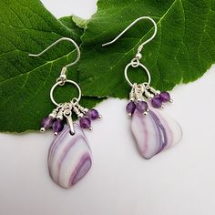 DESCRIPTION| Beautifully feminine and carefully matched up these ocean tumbled wampum shell earrings are fun to wear! See below for more details about these beauties. DETAILS| Approximately 2" total length Sterling silver components  All wire earrings come with rubber stoppers to keep them in place Your purchase supports genuine, surf tumbled sea glass creations PLEASE NOTE| Coins are for scale only and not included in your purchase. Colors may appear different depending on screen settings, monitors & resolution. GIFTING| Gifts can be sent directly to recipients at checkout with the option to include a personal gift message. Your jewelry purchase will come in an organza pouch great for gifting or treating yourself! FAVORITES| Add my shop & items you love to your favorites by clicking on th Nickel-free Lavender Earrings Gift, Adjustable Lavender Sterling Silver Earrings, Gift Lavender Nickel-free Earrings, Adjustable Purple Earrings With Natural Stones, Lavender Earrings With Natural Stones For Gift, Lavender Amethyst Earrings With Ear Wire, Unique Amethyst Purple Earrings, Lavender Ear Wire Earrings For Gift, Lavender Amethyst Earrings With Natural Stones