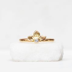 Diamond Snowdrop ring in 14k gold. Three handmade petals surround a sparkly white diamond. Comes on a 14k gold band with a hammered texture. Details : Diamond - 2.5mm Band - 1.6mm, hammered texture Finish - Choose between brushed satin and a shiny high polish at checkout. Pictured with the brushed satin finish. It's important to note that the photos are enlarged to show detail which can make the jewelry appear much larger than it is. Please look up the measurements I have noted on a ruler before 14k Gold Wedding Flower Ring With Diamond Accents, Yellow Gold Flower Ring With Single Diamond For Promise, Gold Flower Ring With Single Diamond For Wedding, Gold Wedding Flower Ring With Single Diamond, Yellow Gold Flower Ring With Single Diamond, Wedding Flower Ring With Single Diamond, Gold Flower Ring With Single Cut Diamonds For Promise, Gold Flower Ring With Single Diamond, Yellow Gold Flower Ring With Single Diamond For Wedding