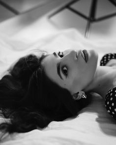 a black and white photo of a woman laying on a bed