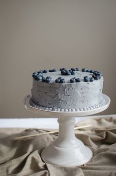 a white cake with blue berries on top