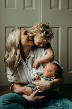 a woman holding a baby and smiling at the camera while she holds it up to her face