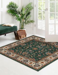 a green rug with an ornate design on it in front of a door and window