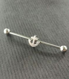 a pair of silver balls and a cross on a barbell ring with two screws