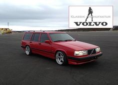 a red volvo station wagon parked in a parking lot next to a sign that says klassie nuritatur volvo