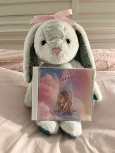 a stuffed bunny holding a book with the word love written on it's front