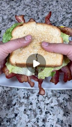 someone is holding up a bacon and lettuce sandwich