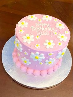 a pink and white cake with flowers on it