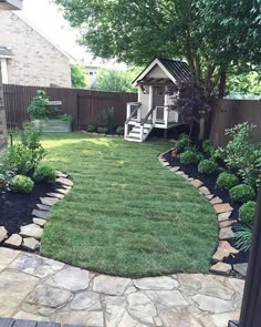 a backyard with grass, rocks and trees