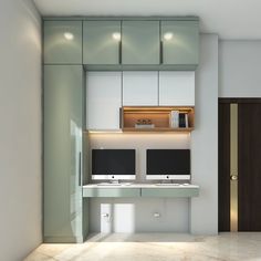 a computer desk with two monitors on top of it in front of a wall mounted cabinet