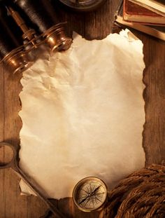 an old paper, compass and rope on a wooden table with other items stock photo