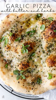 a pizza sitting on top of a pan covered in cheese and herbs