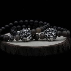 🐲 Guardian Spirits of Serenity and Vigilance: Introducing my dual Shisa Bracelets set. Each embodying a sacred guardian. One bracelet features a Shisa with its mouth open, actively warding off evil spirits, while the other showcases a Shisa with its mouth closed, preserving peace within. 🖤 Surrounded by deep black onyx beads and vivid tiger's eye stones, these bracelets connect the spiritual protection of a temple to the sanctity of your body. 🌟 Choose the open mouth for active protection or Silver Onyx Beaded Bracelets Hand-strung, Hand-strung Silver Onyx Beaded Bracelets, Black Sterling Silver Jewelry With 8mm Beads, Silver Onyx Bracelet With Gemstone Beads, Silver Onyx Bracelets With Gemstone Beads, Silver Onyx Beaded Bracelets As Gift, Silver Onyx Beaded Bracelets For Gift, Silver Onyx Bracelets With 8mm Beads, Sacred Circle