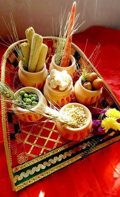 an assortment of vegetables in small bowls on a red tableclothed tray with gold trim