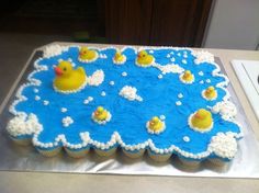 there is a cake that has rubber ducks in the water on it, and white frosting