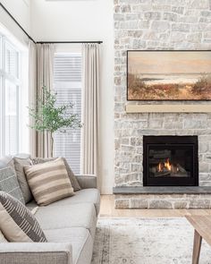 a living room filled with furniture and a fire place next to a painting on the wall