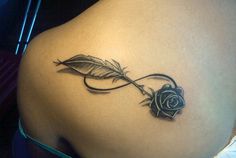 a tattoo on the back of a woman's stomach with a rose and leaf