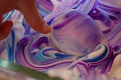 someone is painting something with purple and blue colors