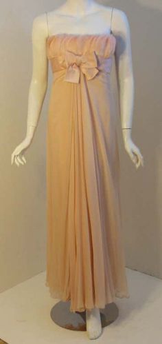 For Sale on 1stDibs - This is a rare vintage light pink peach chiffon gown by Sarmi, from the 1960's. The gown has feathers all around the bust, a silk sash and bow, a constructed Elegant Apricot Evening Dress, Elegant Peach Evening Dress For Wedding, Elegant Peach Evening Gown, Fitted Peach Evening Gown, Elegant Peach Gown For Party, Elegant Peach Floor-length Gown, Elegant Peach Evening Dress, Elegant Peach Wedding Gown, Vintage Peach Evening Dress