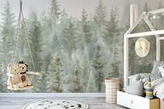 a child's bedroom with a forest wallpaper and teddy bear on the swing