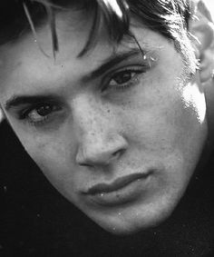 black and white photograph of a young man with freckled hair looking at the camera