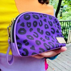 With bright 90's-inspired colors and our electric purple leopard print featuring hearts, lips, and lightning bolts sprinkled among the spots, this cute little pouch is perfect for carrying your makeup, period gear, manicure supplies, jewelry or any little thing you want. Features a lightning bolt zipper pull, pleather accents, pleather wristlet strap, and hot pink lining. Purple Electric Leopard print on polyester canvas Gold tone metal lightning bolt zipper pull and gold zipper Bright pink nylo Trendy Purple Cosmetic Bag With Zipper Pouch, Purple Pencil Case With Zipper Closure As Gift, Trendy Purple Pouch For Gifts, Trendy Purple Pouch For Gift, Purple Cosmetic Bag With Zipper For Everyday, Trendy Purple Pencil Case For Daily Use, Trendy Purple Zipper Pouch Cosmetic Bag, Purple Zipper Cosmetic Bag For Everyday Use, Purple Zipper Pouch Cosmetic Bag For Personal Use