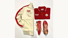 a pair of red tennis shoes next to a white jacket and some other items on a table