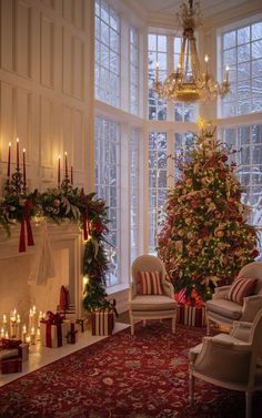 a living room with a christmas tree in the corner and many candles on the fireplace