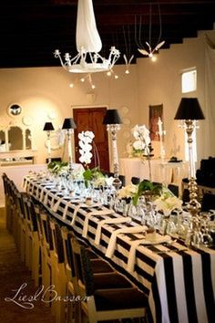 a long table is set with black and white linens