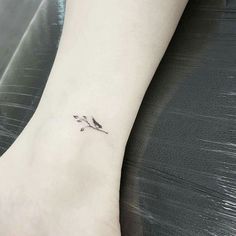 a small flower tattoo on the ankle