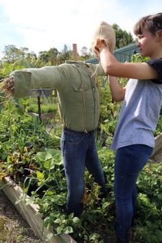 two people standing in a garden, one holding an object over the other's head