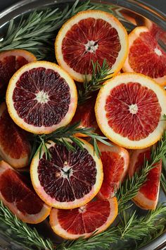 grapefruits with rosemary sprigs in a bowl