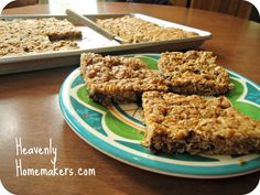 homemade granola bars sitting on a plate next to a pan of baking utensils