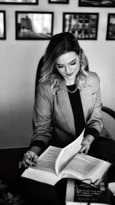 a woman sitting at a desk reading a book